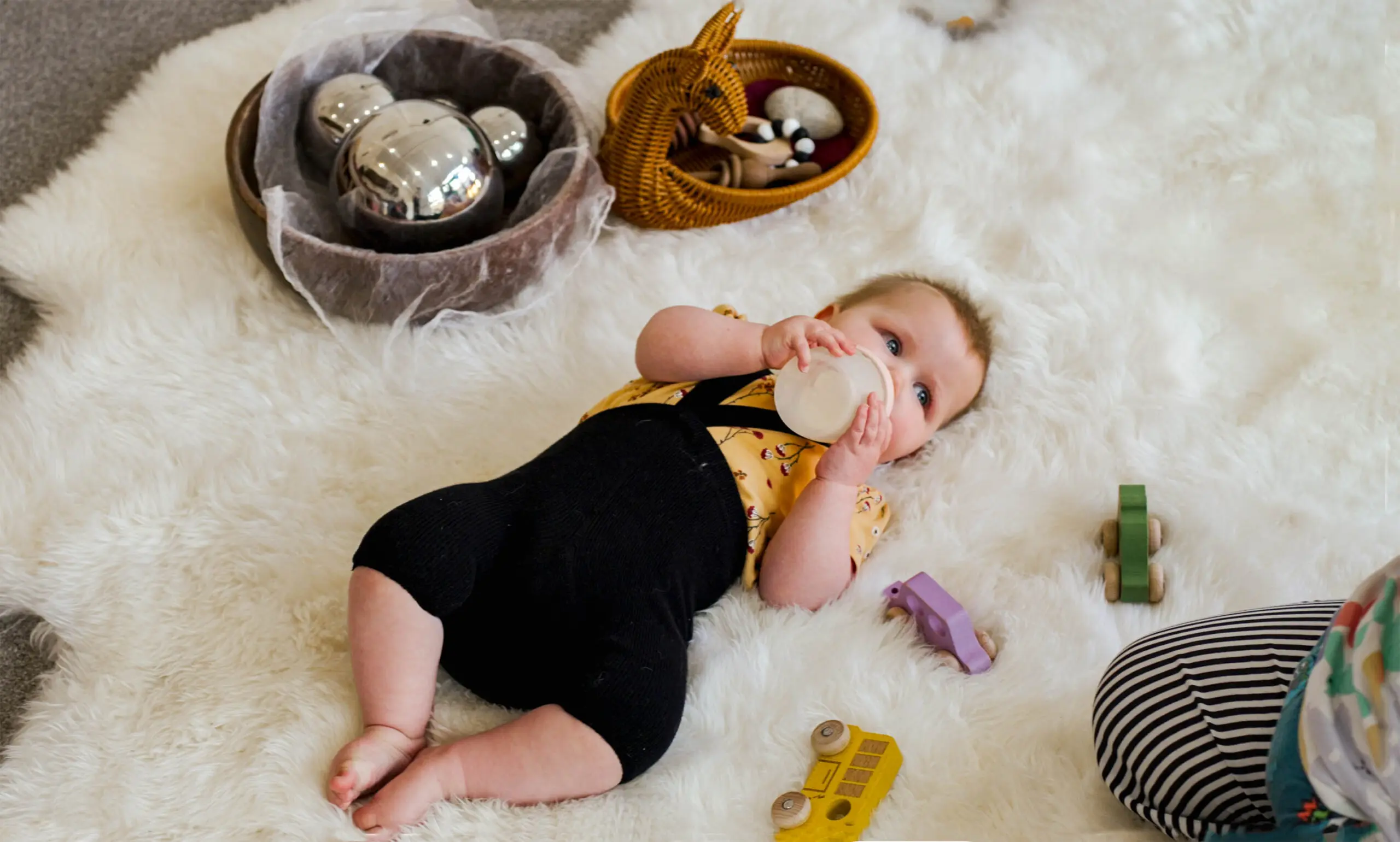 A pēpi playing on the floor at Manawa